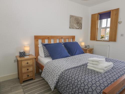 um quarto com uma cama com almofadas azuis e uma janela em All Aboard em Whitby