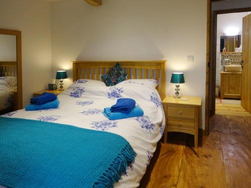 um quarto com uma cama com almofadas azuis em The Woodshed em Upton Pyne