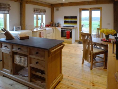 a kitchen with a island in the middle of a room at The Woodshed in Upton Pyne