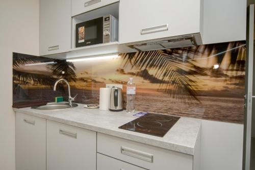 a kitchen with a sink and a counter top at Arena Summit Apart Hotel in Kyiv