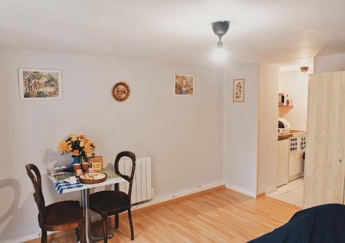 a living room with a table and chairs and a kitchen at Chez Sophie - Part Die in Lyon