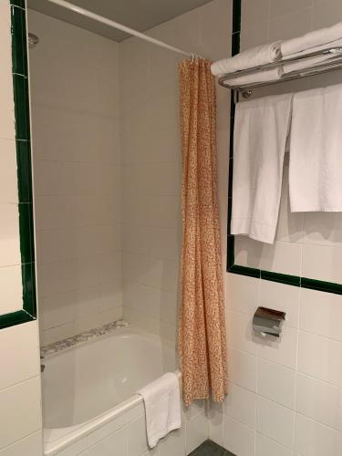 a bathroom with a tub and a shower with towels at Hotel Área de Calahorra in Calahorra
