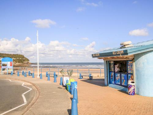 a building on the beach with the ocean in the background at Casita in Benllech