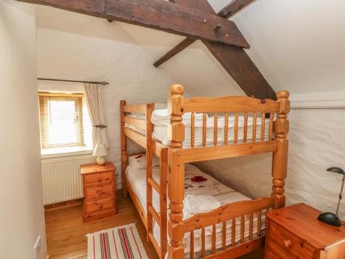 a bedroom with two bunk beds in a attic at Primose Cottage in Milford Haven