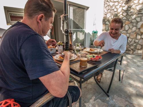 a man and a woman sitting at a table eating food at Silba Otium in Silba
