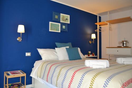 a blue bedroom with a large bed with white pillows at Be Blu Apartment in Naples