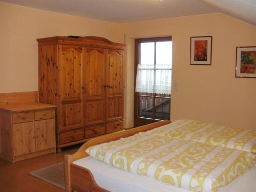 sypialnia z łóżkiem, komodą i oknem w obiekcie Ferienwohnung Klaus w mieście Oy-Mittelberg