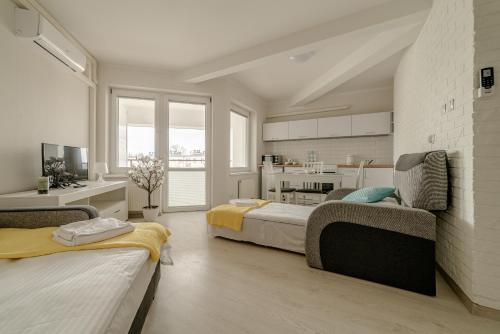 a living room with two beds and a kitchen at GUZ Apartamenty in Giżycko