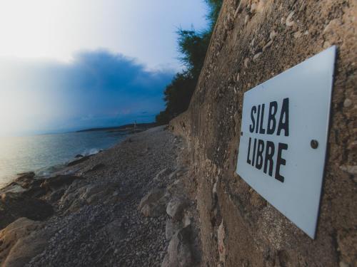 a sign on the side of a rocky beach at Silba Otium in Silba