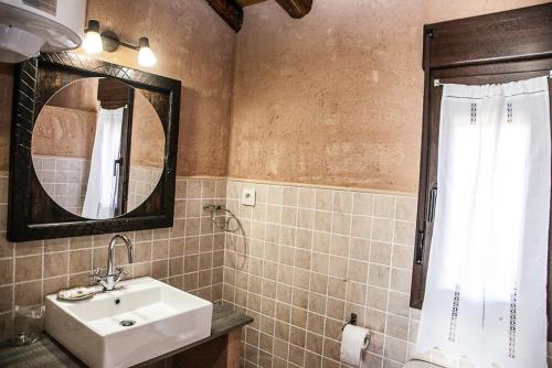 a bathroom with a sink and a mirror at Apartamentos Rurales El Casarejo in Cantalojas