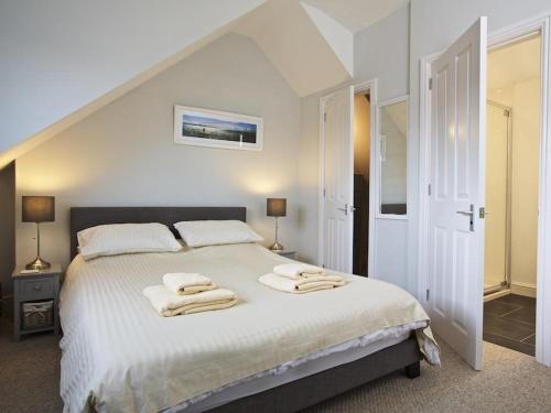 ein Schlafzimmer mit einem großen weißen Bett mit Handtüchern darauf in der Unterkunft Crab Cottage in Salcombe
