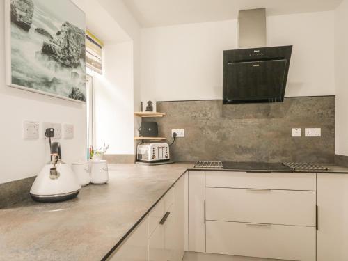 a kitchen with white cabinets and a counter top at Faodail Glenlia in Foyers