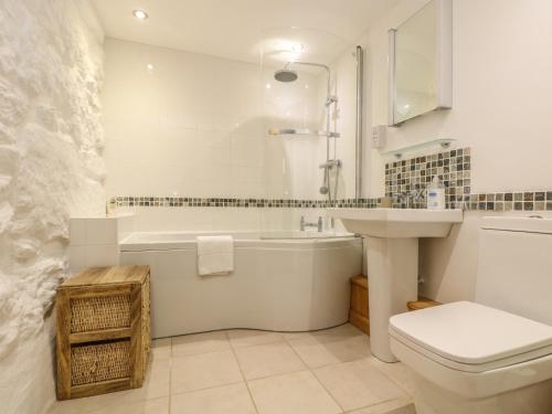 a bathroom with a tub and a toilet and a sink at Barneys Barn in Penzance