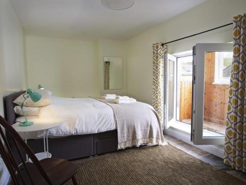 a bedroom with a bed and a table and a window at Chapel House in Dartmouth