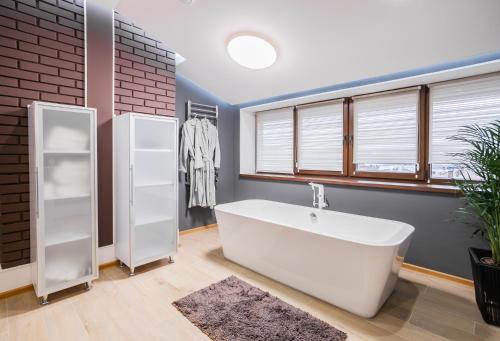 a bathroom with a large white tub and a window at Amsterdam Lviv Apartments in Lviv
