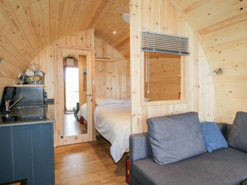 een slaapkamer met een bed in een houten hut bij Garraidh Ghorm Pod in Portree