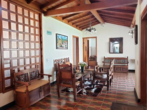 a dining room with a table and chairs at Hotel Casa Floralia in Tibasosa
