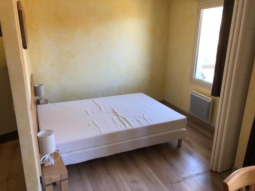 uma cama branca num quarto com uma janela em Les Terrasses d Isola 2 pièces 4 personnes em Isola 2000