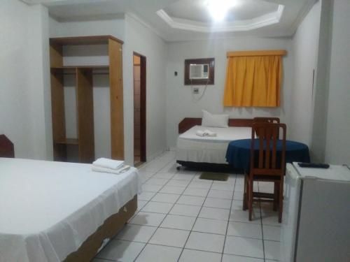 um quarto com duas camas e uma cadeira em NEW BUSINESS em Macapá