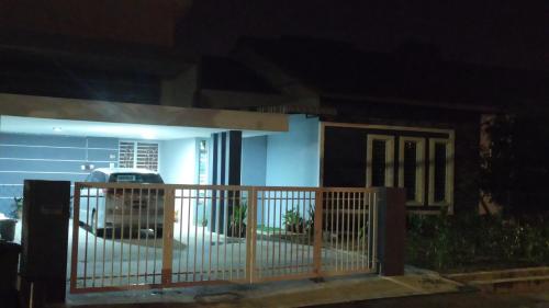 a house with a gate and a parking lot at night at FRA Homestay in Kuantan