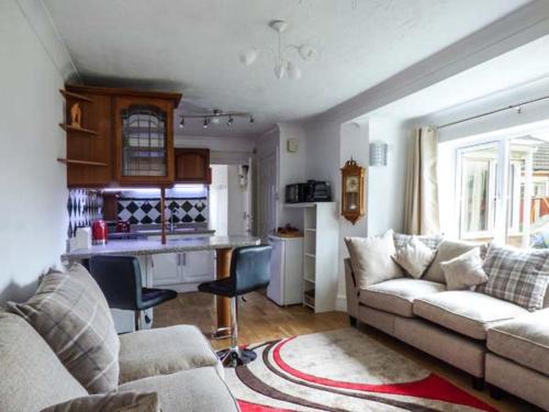 a living room with a couch and a kitchen at The Old Clockmakers in Norwich