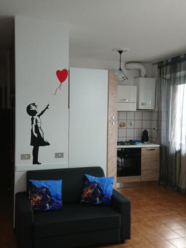 sala de estar con sofá y pegatina de corazón roja en Casa Emilia Loano, en Loano