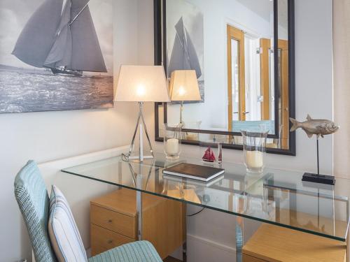 a glass desk with two lamps and a table with chairs at 7 Dart Marina in Dartmouth