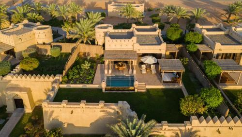 an aerial view of a mansion with a swimming pool at Anantara Qasr al Sarab Desert Resort in Jurayrah