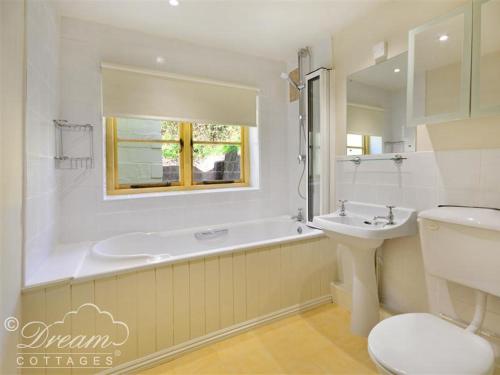 a bathroom with a tub and a sink and a toilet at Valley View Farm Annexe in Uplyme