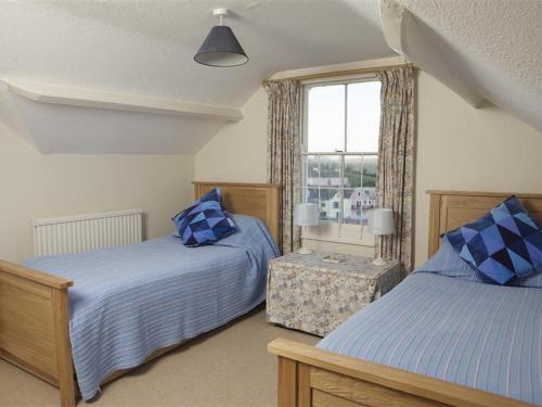 a bedroom with two beds and a window at 7 Glenthorne House in Salcombe