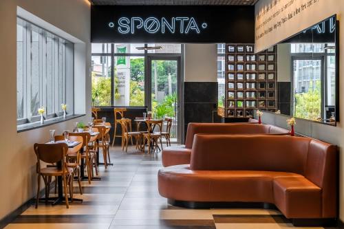 a restaurant with leather couches and tables and chairs at Ibis Styles SP Centro in Sao Paulo
