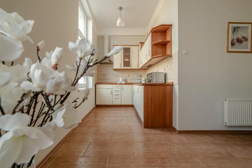 uma cozinha com flores brancas no primeiro plano em GUZ Apartamenty em Giżycko
