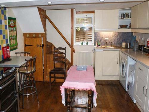 a kitchen with a table with a pink blanket on it at 2 Llawrcoed Isaf in Llanbrynmair