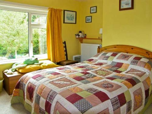 a bedroom with a bed and a window at 2 Llawrcoed Isaf in Llanbrynmair