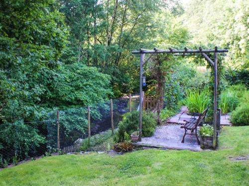 a garden with a bench and a fence at 2 Llawrcoed Isaf in Llanbrynmair