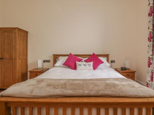 una camera da letto con un letto con cuscini rosa di Hillcrest a Newton Stewart