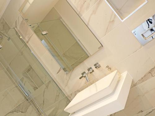 a white bathroom with a sink and a mirror at Little Fistral in Newquay