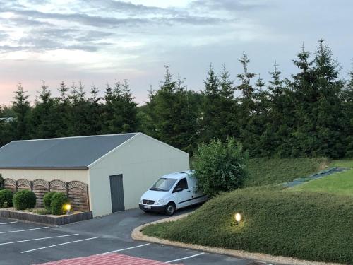 a white van parked in a parking lot at Villa Motel in Stenay