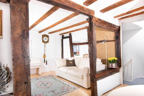 uma sala de estar com um sofá branco e vigas de madeira em Alte Uhrmacherei em Heimbach