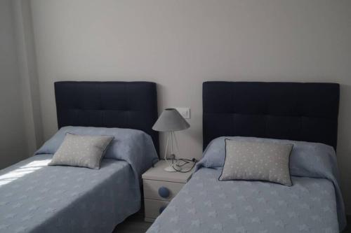 Duas camas sentadas uma ao lado da outra num quarto em Apartamentos los Acantilados Nº 1 Cobreces em Cóbreces