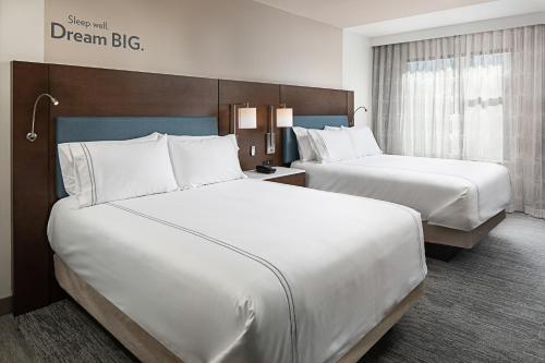 a hotel room with two beds and a sign that reads dream big at EVEN Hotel Alpharetta - Avalon Area, an IHG Hotel in Alpharetta
