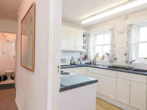 eine Küche mit weißen Schränken und einer Arbeitsplatte in der Unterkunft 8b Fore Street in Salcombe
