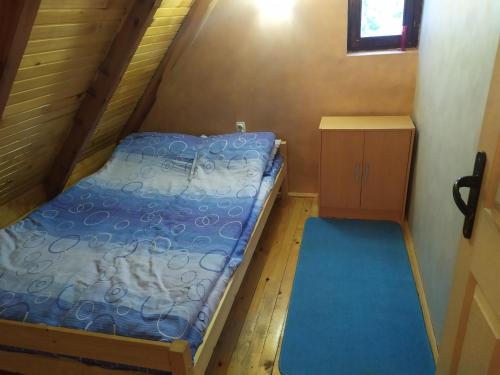 a small bedroom with a bed and a small cabinet at Vila Balerina in Mitrovac