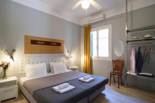 アテネにあるAthens Green Apartmentsのベッドとタオル2枚のある寝室