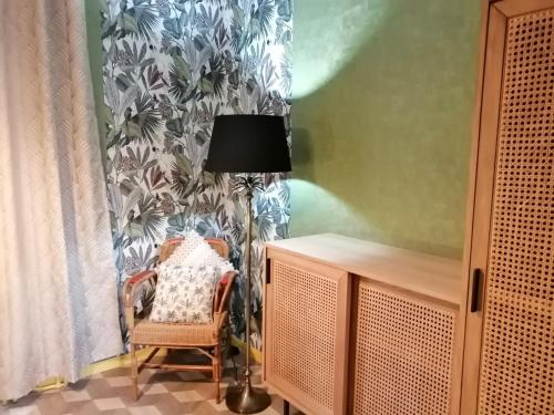 a lamp and a chair in a room with a curtain at Villa Étienne in Le Mont-Dore