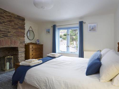 a bedroom with a large bed and a window at Armada Cottage in Dartmouth