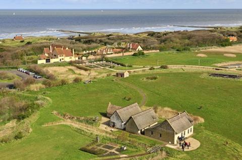 an aerial view of a house on a field with the ocean at les terrasses2 in Ostend