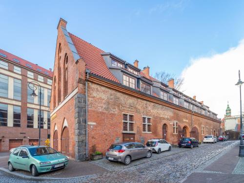 a group of cars parked in front of a brick building at Hostel Universus in Gdańsk
