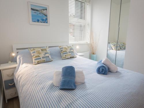 una camera da letto con un letto e asciugamani di The Apartment, Newcomen Road a Dartmouth