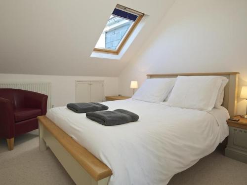 a bedroom with a large white bed with two pillows on it at 9 Prospect House in Kingsbridge